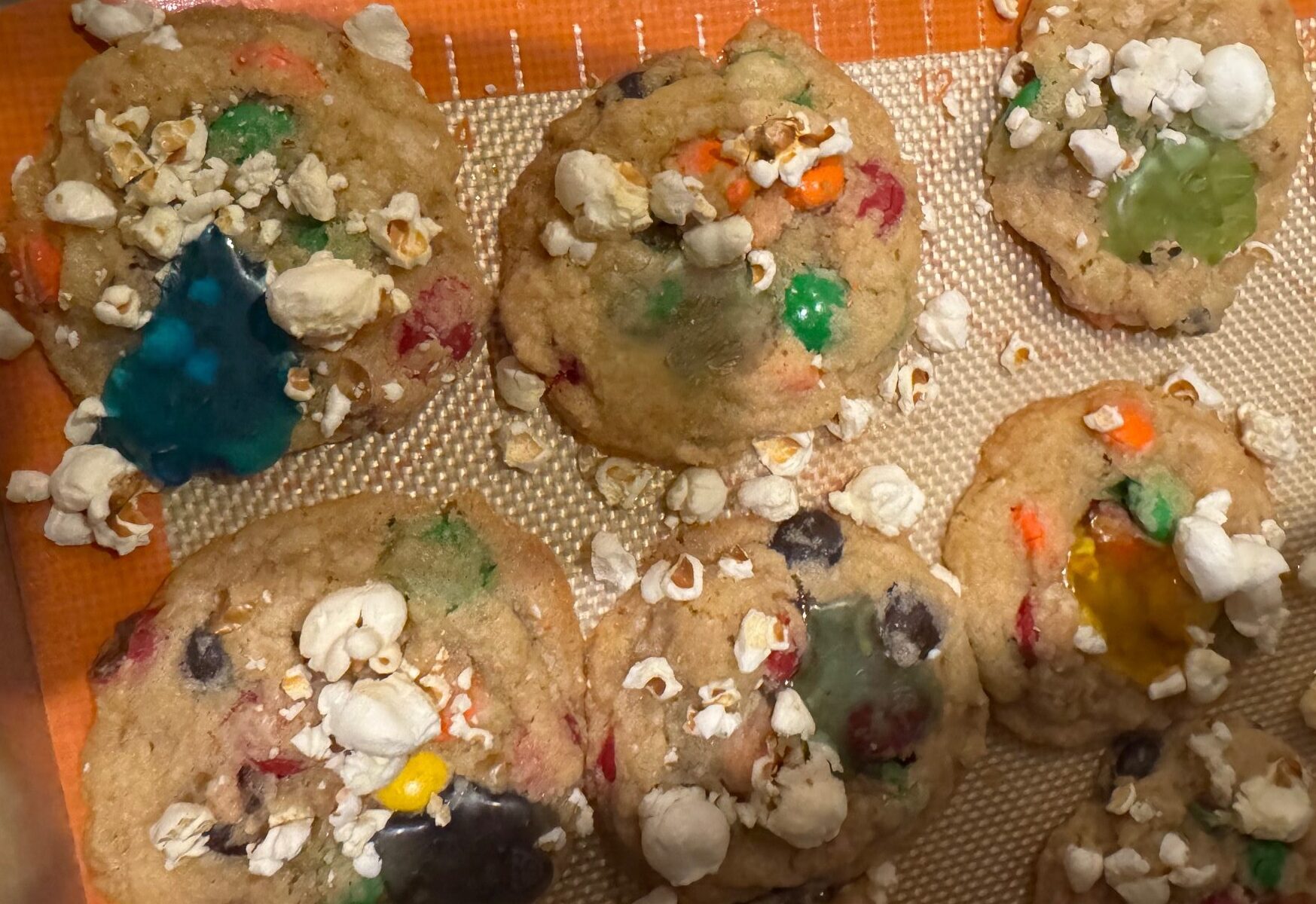 Cookies topped with popcorn bits and colorful melted gummi bears.