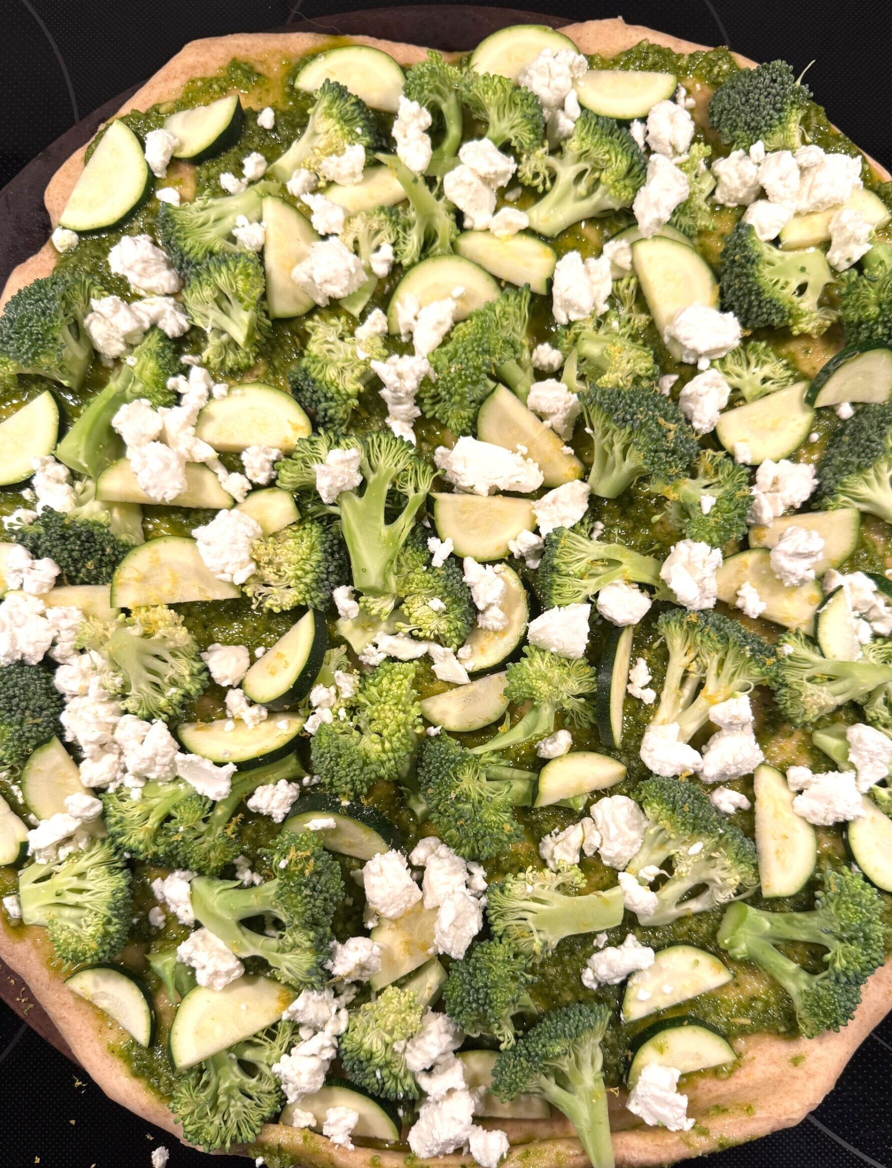 Round pizza topped with green broccoli.